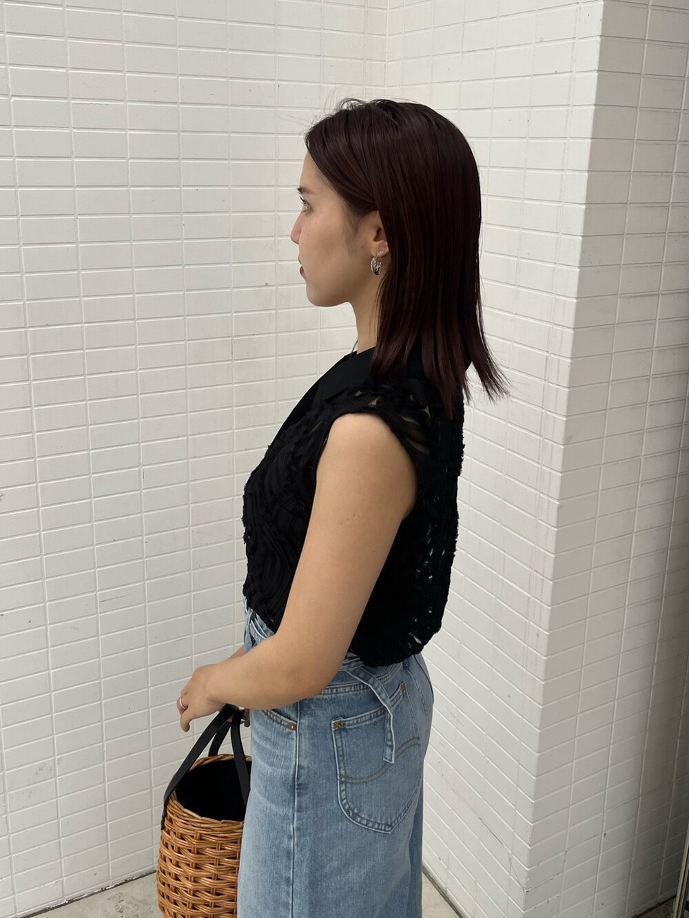 ブラウン系のハンドバッグ、ブラック系のサンダル、ブラック系のシャツ/ブラウスを着用したレディースの夏コーディネートの7枚目の写真