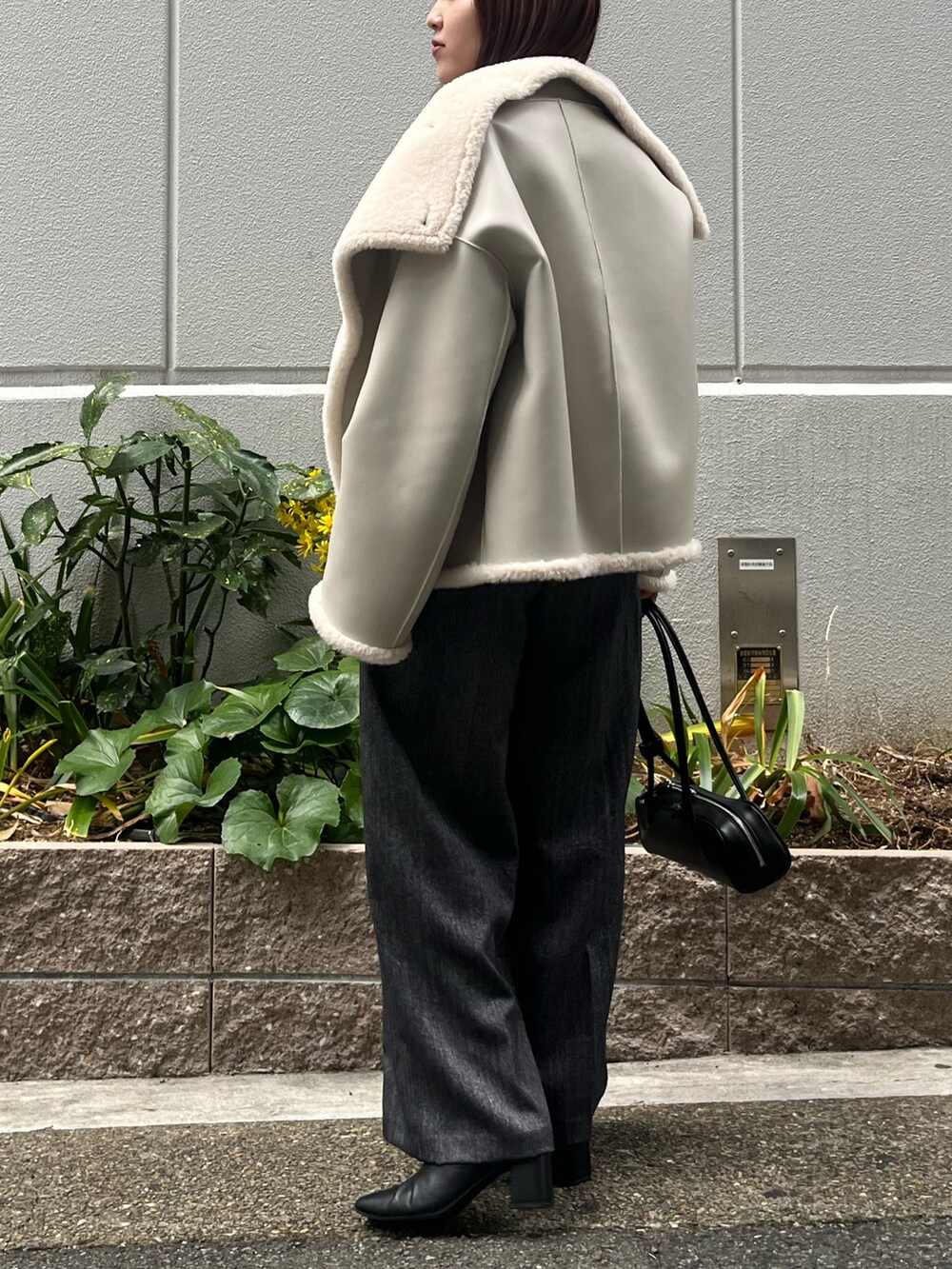 ホワイト系のムートンコート、グレー系のその他パンツ、グリーン系のニット/セーターを着用したレディースの冬コーディネートの3枚目の写真