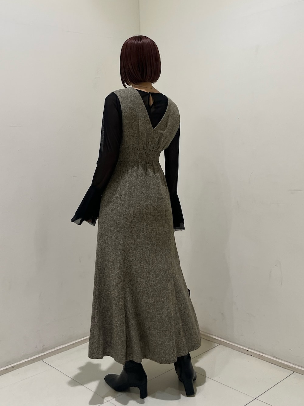 ベージュ系のジャンパースカート、ブラック系のTシャツ/カットソー、ブラック系のブーツを着用したレディースの秋コーディネートの3枚目の写真