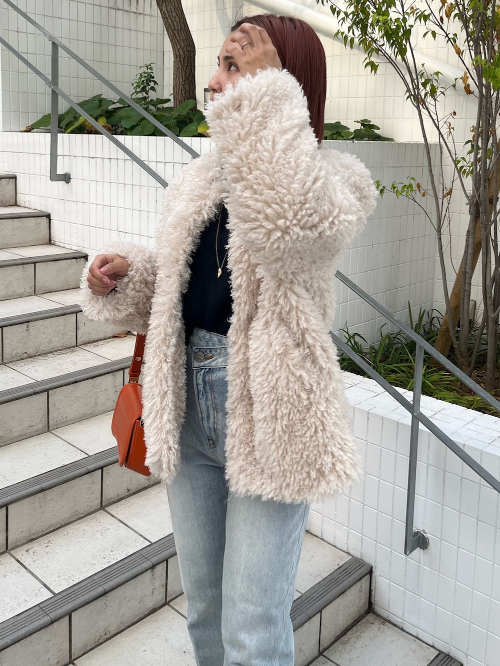 ブルー系のニット/セーター、ホワイト系のその他アウター、ブルー系のデニムパンツを着用したレディースの秋コーディネートの8枚目の写真
