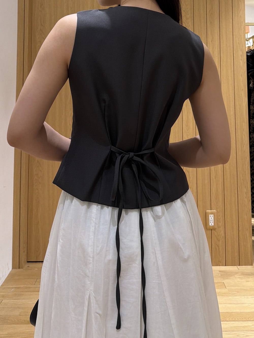 ブラック系のパンプス、グレー系のワンピース、ブラック系のハンドバッグを着用したレディースの夏コーディネートの6枚目の写真