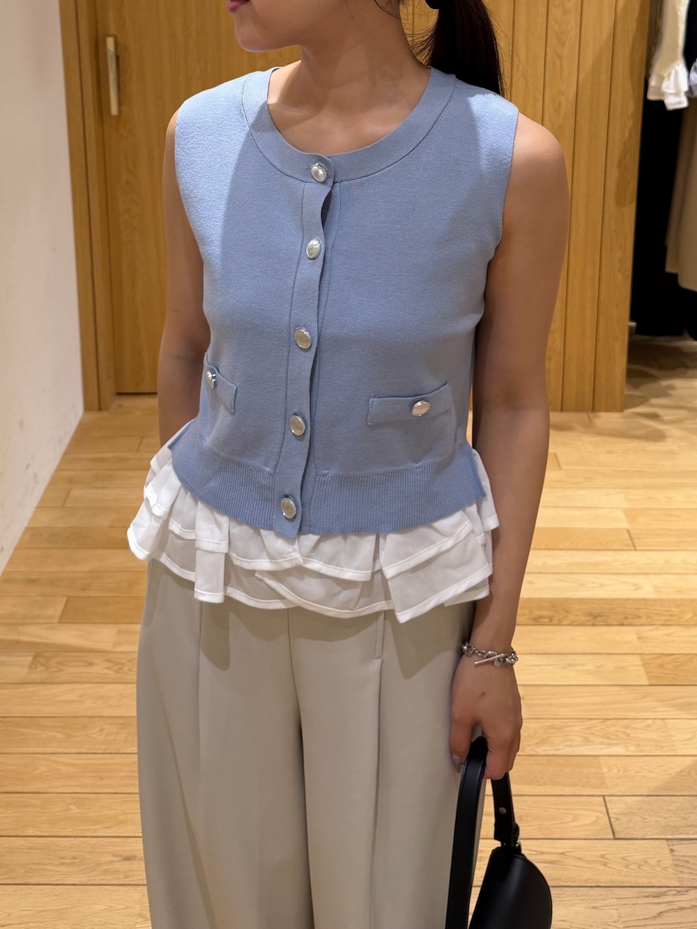 ホワイト系のその他パンツ、ブラック系のパンプス、ブラック系のハンドバッグを着用したレディースの夏コーディネートの4枚目の写真