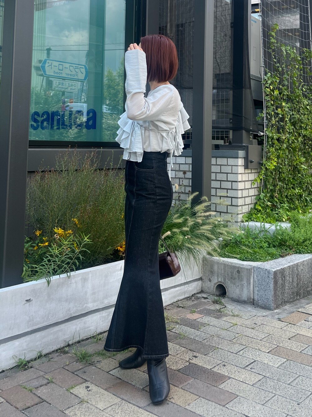 ブラック系のデニムスカート、ブルー系のシャツ/ブラウス、レッド系のショルダーバッグを着用したレディースの秋コーディネートの2枚目の写真