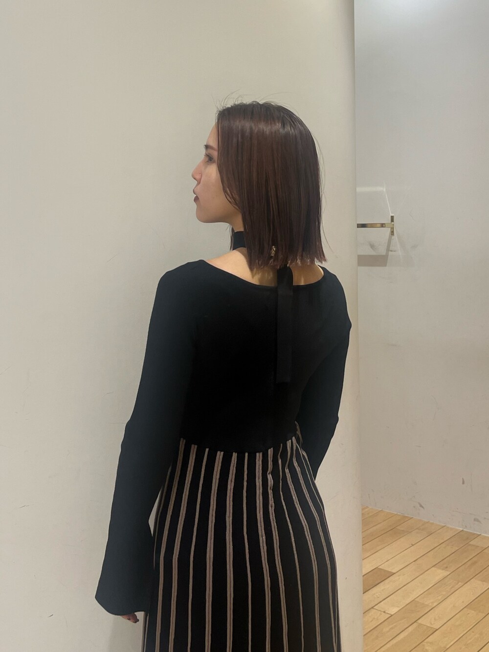 ブラック系のワンピース、ブラック系のブーツを着用したレディースの冬コーディネートの6枚目の写真