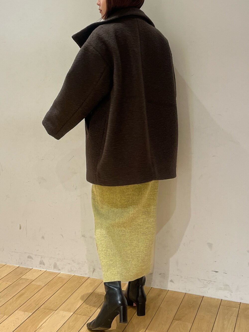 ブラウン系のその他アウター、グリーン系のワンピース、ブラック系のブーツを着用したレディースの冬コーディネートの3枚目の写真