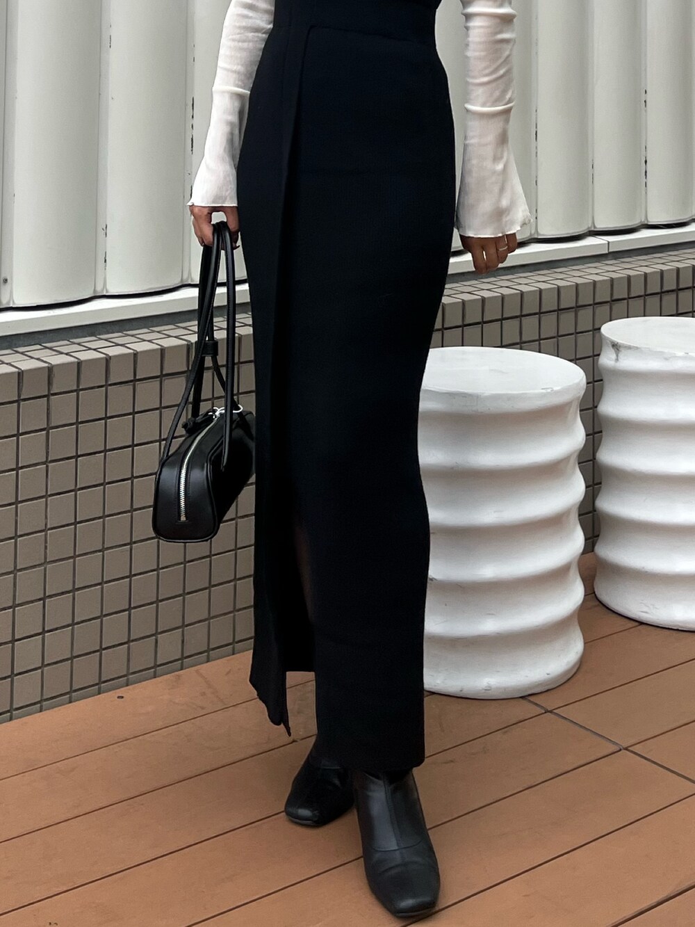 ブラック系のショルダーバッグ、ブラック系のワンピース、ホワイト系のTシャツ/カットソーを着用したレディースの秋コーディネートの7枚目の写真