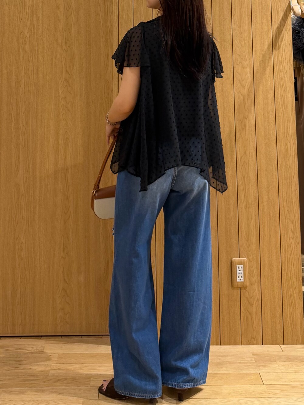 ブルー系のデニムパンツ、ブラウン系のサンダル、ブラウン系のハンドバッグを着用したレディースの春コーディネートの3枚目の写真