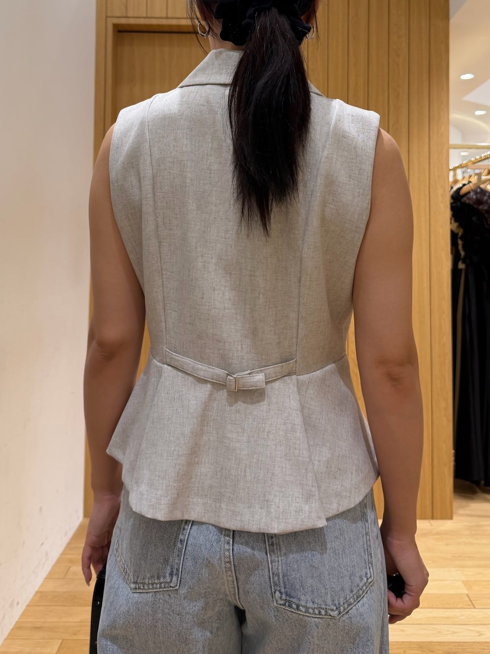 ブルー系のデニムパンツ、ホワイト系のベストを着用したレディースの春コーディネートの5枚目の写真