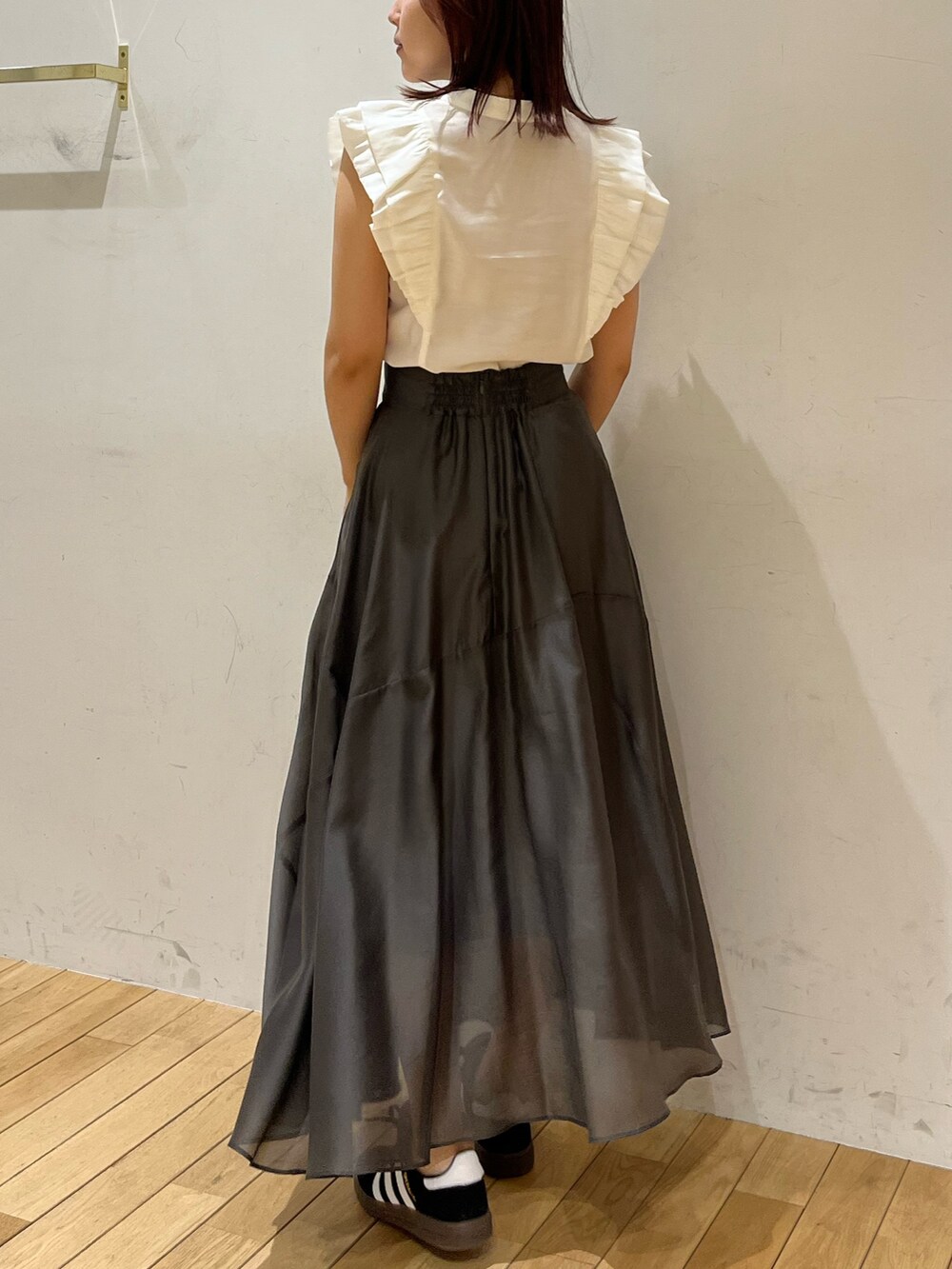 ブラック系のスニーカー、ホワイト系のシャツ/ブラウス、グレー系のスカートを着用したレディースの春コーディネートの3枚目の写真