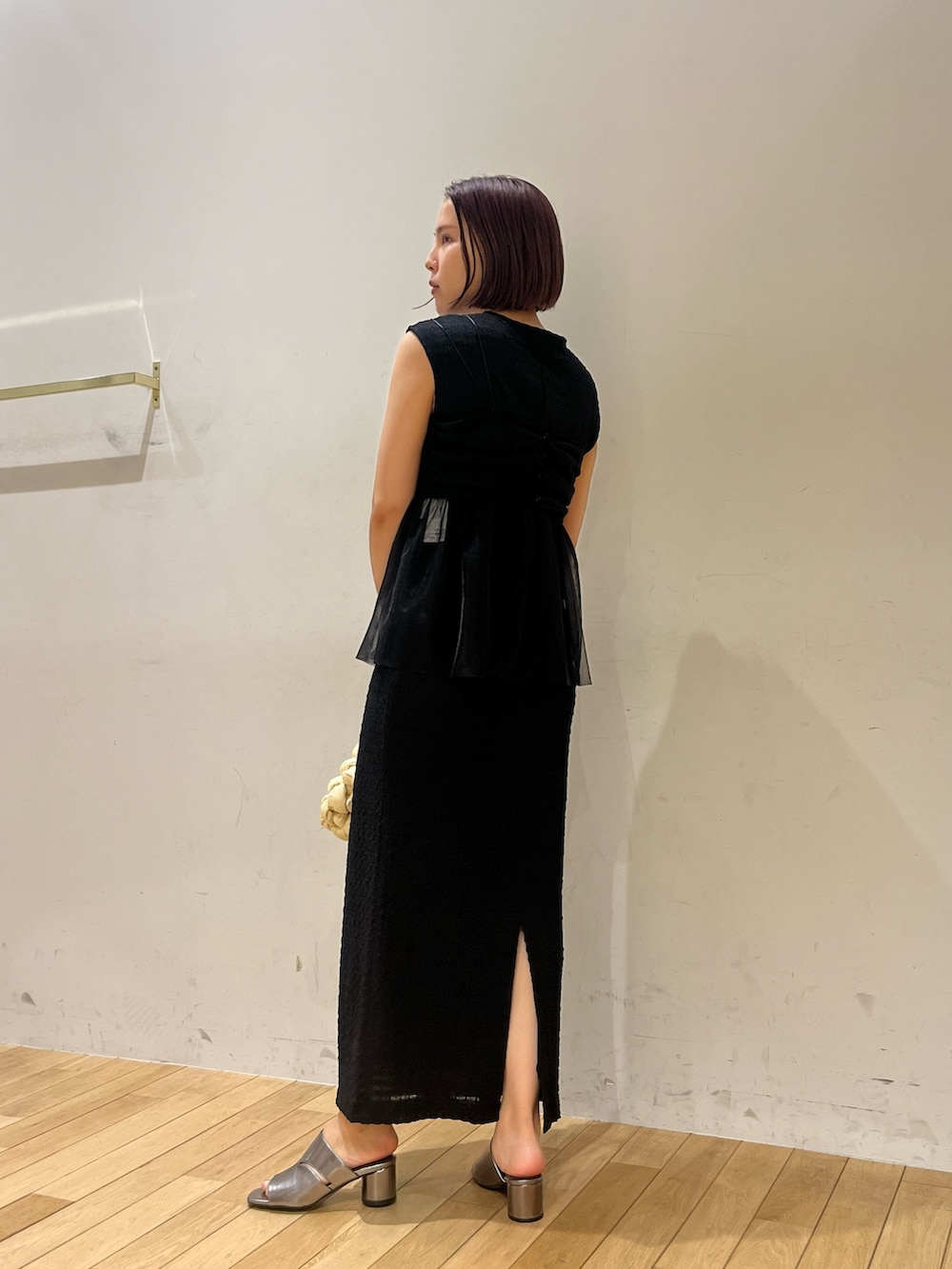 ホワイト系のハンドバッグ、ブラック系のワンピース、その他のサンダルを着用したレディースの夏コーディネートの3枚目の写真