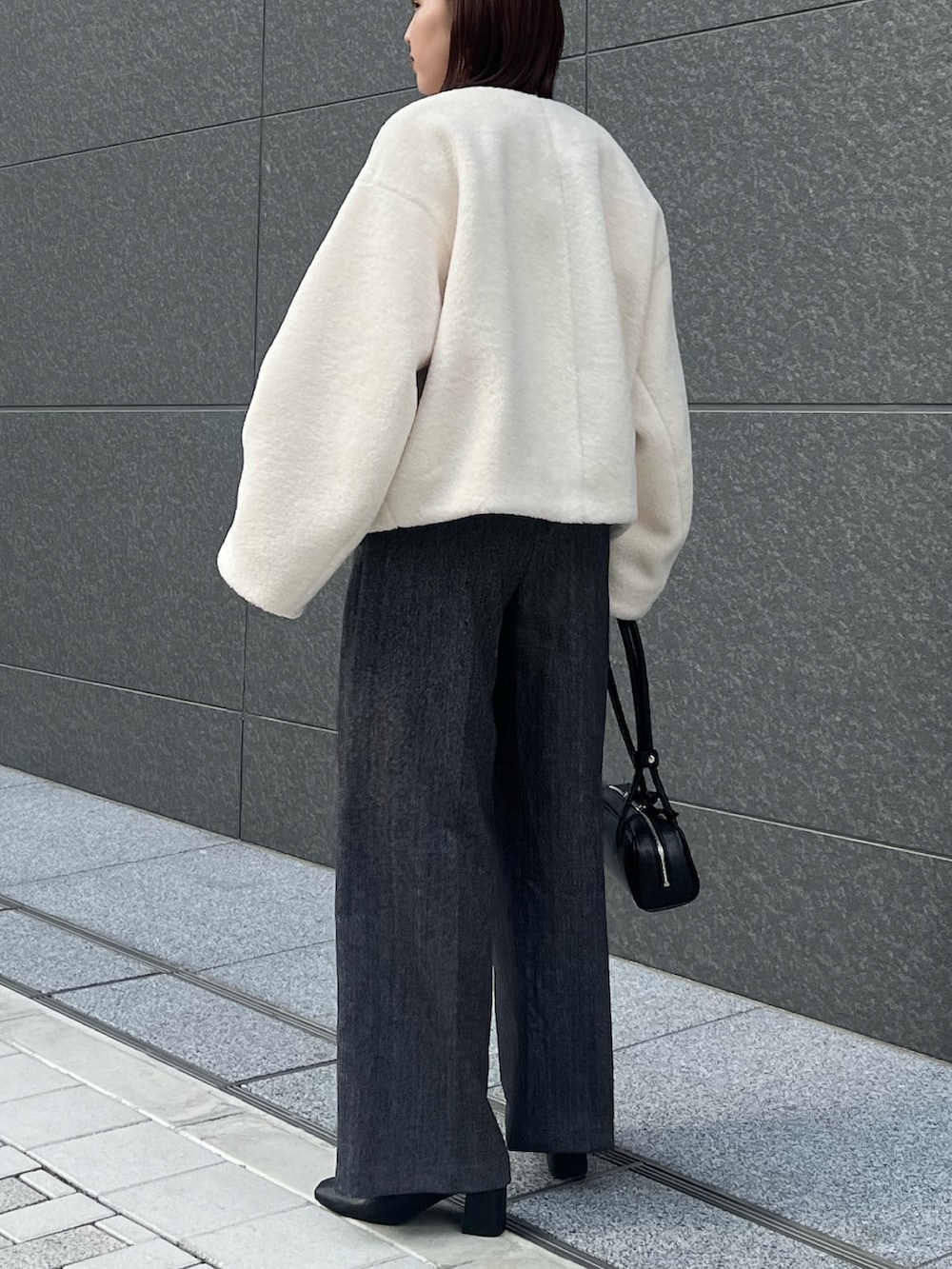 グレー系のその他パンツ、ホワイト系のニット/セーター、ホワイト系のブルゾンを着用したレディースの冬コーディネートの4枚目の写真
