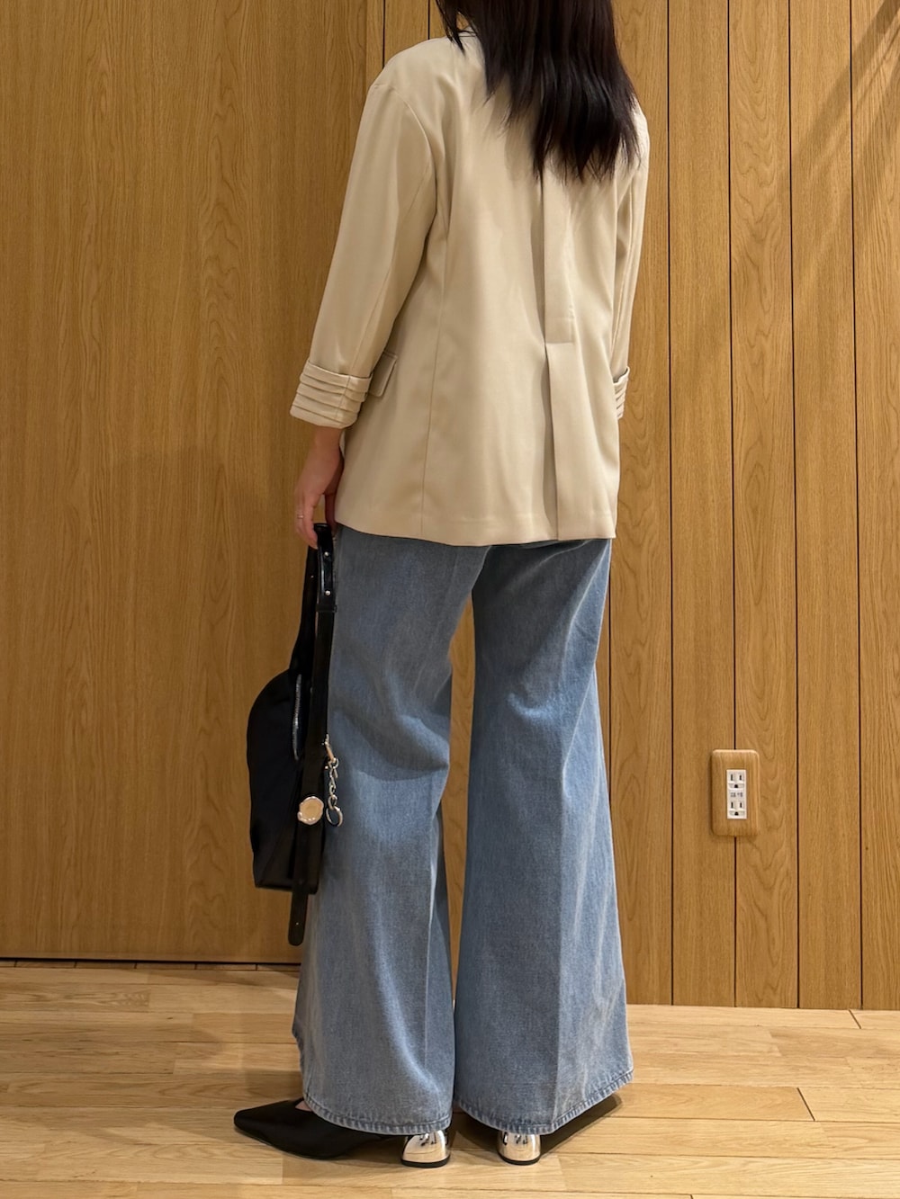 ブルー系のデニムパンツ、ホワイト系のタンクトップ、ベージュ系のテーラードジャケットを着用したレディースの春コーディネートの3枚目の写真