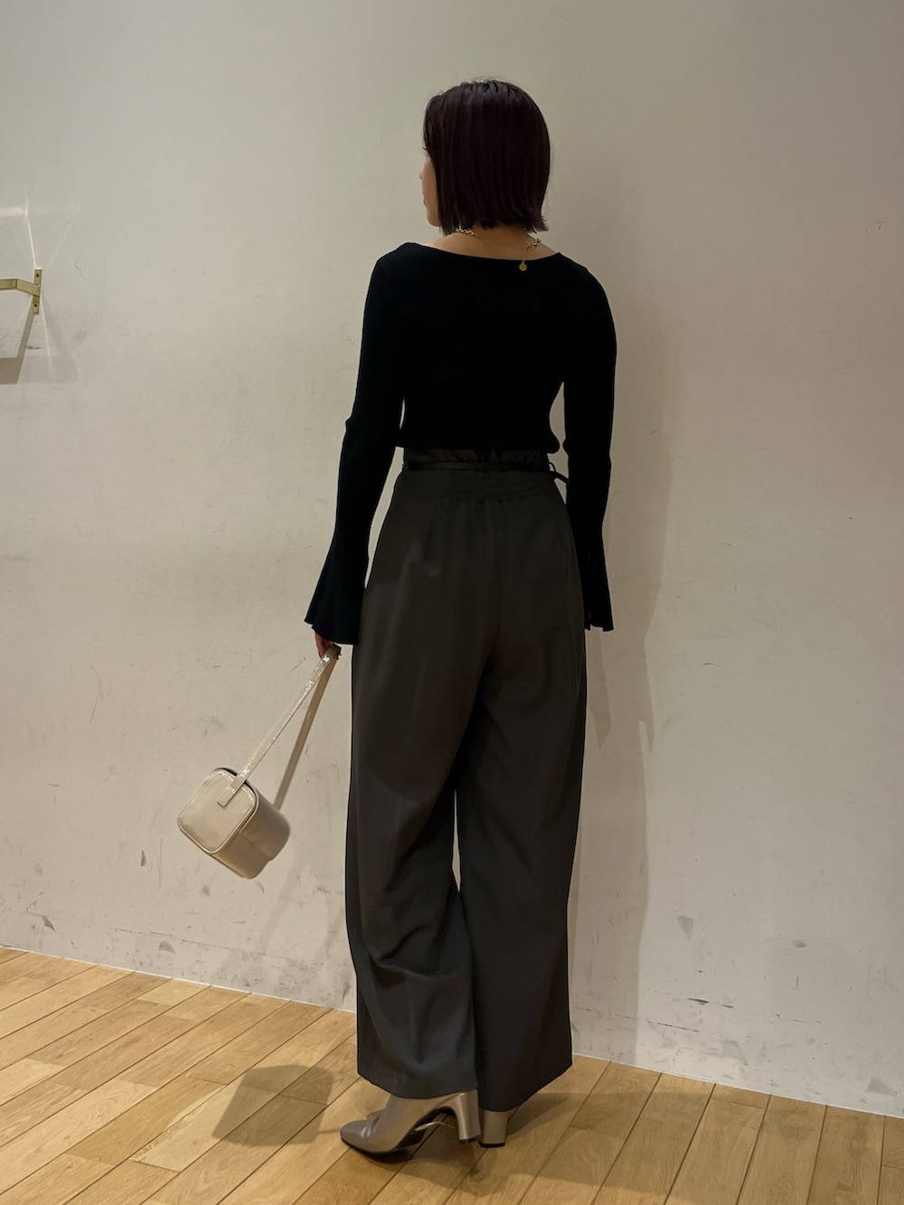 グレー系のその他パンツ、シルバー系のブーツ、ホワイト系のショルダーバッグを着用したレディースの秋コーディネートの3枚目の写真