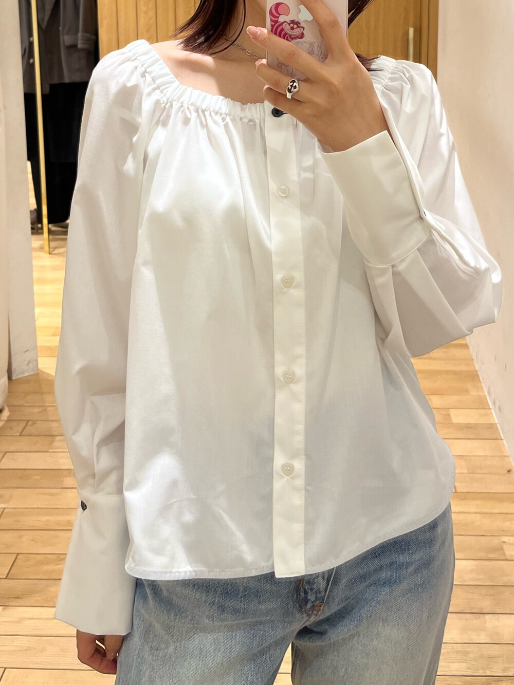 ブルー系のデニムパンツ、シルバー系のサンダル、ブラウン系のハンドバッグを着用したレディースの春コーディネートの7枚目の写真