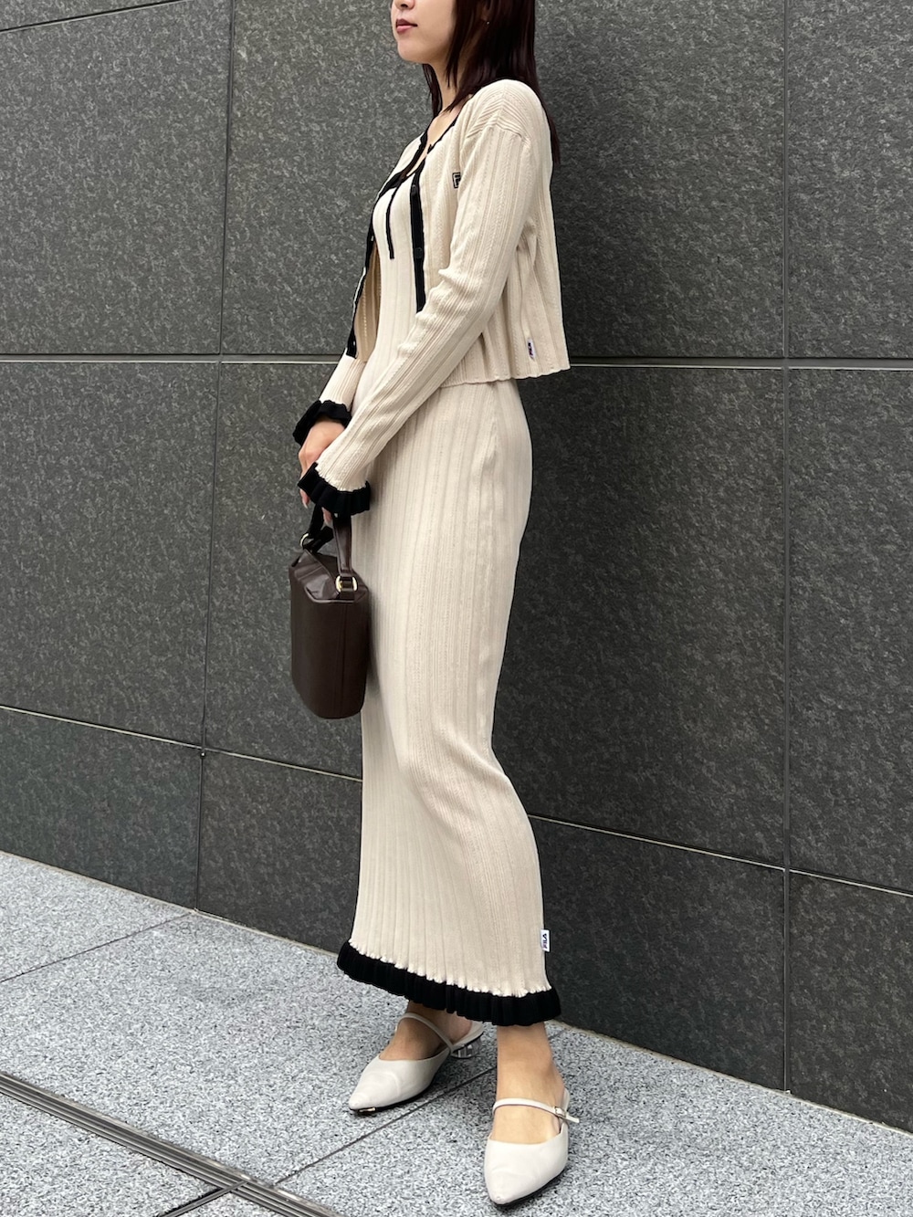 ブラウン系のハンドバッグ、ベージュ系のワンピース、ベージュ系のカーディガン/ボレロを着用したレディースの冬コーディネートの2枚目の写真