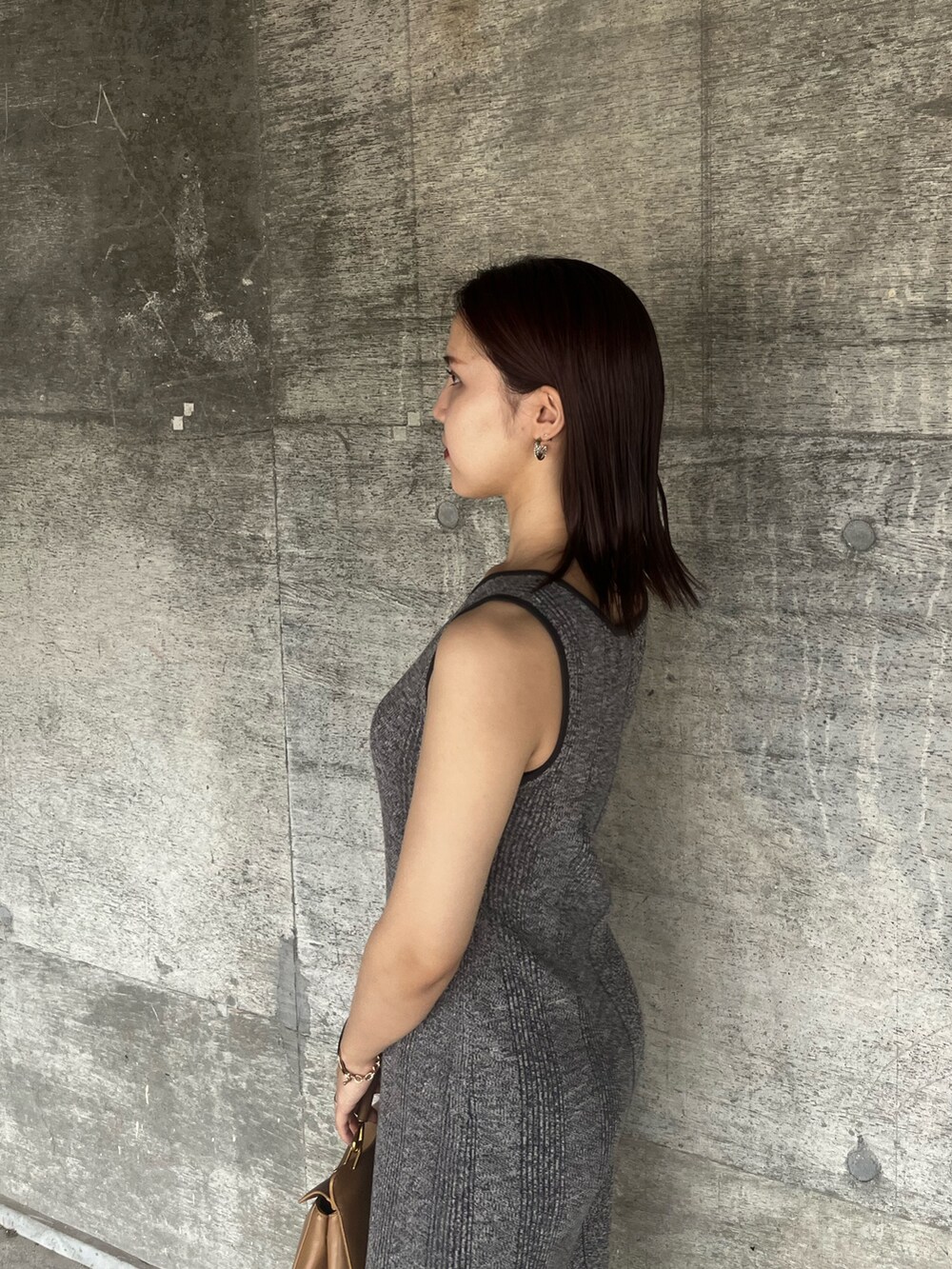 ブラック系のサンダル、グレー系のワンピース、ブラウン系のハンドバッグを着用したレディースの夏コーディネートの5枚目の写真