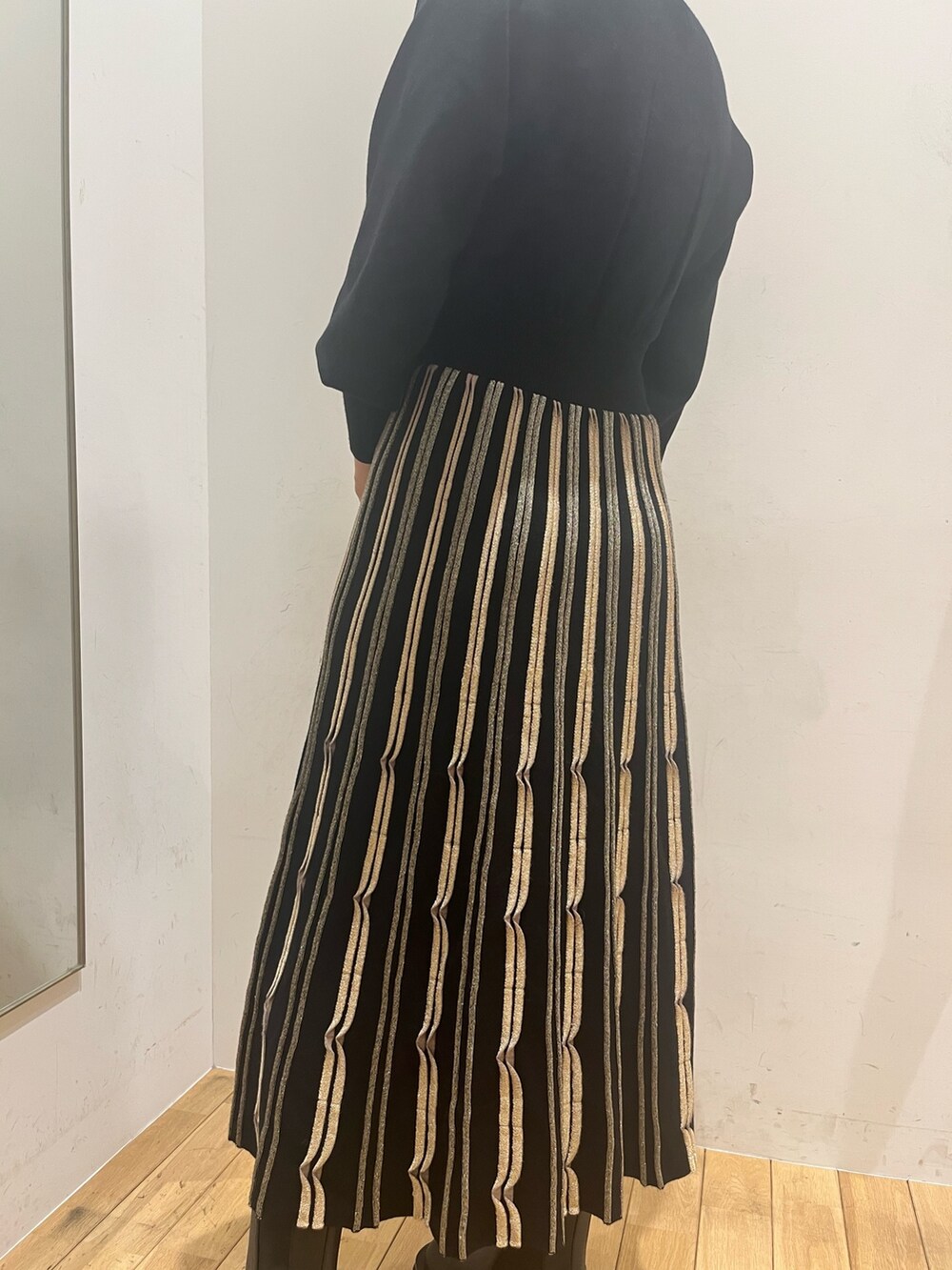 ブラック系のワンピース、ブラウン系のショルダーバッグ、ブラック系のダウンジャケット/コートを着用したレディースの秋コーディネートの8枚目の写真