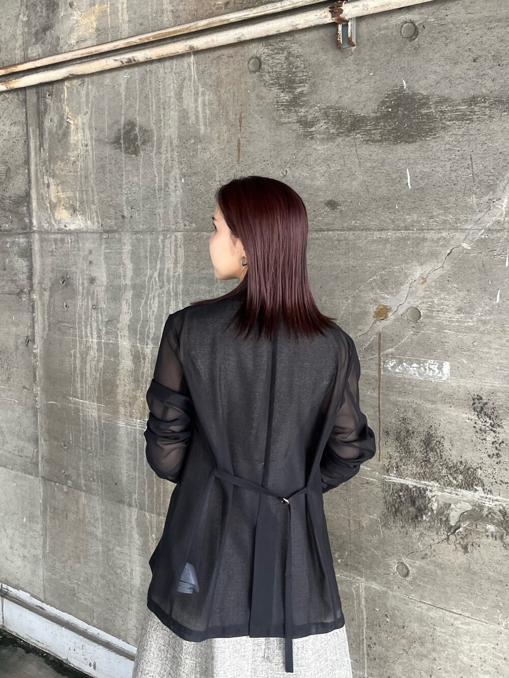 ブラック系のテーラードジャケット、ブラウン系のワンピース、ブラウン系のハンドバッグを着用したレディースの夏コーディネートの5枚目の写真