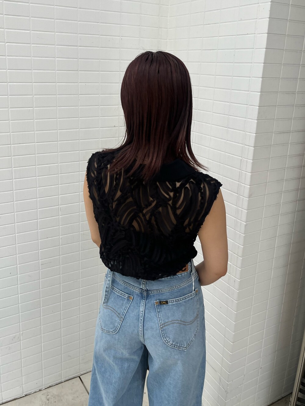 ブラウン系のハンドバッグ、ブラック系のサンダル、ブラック系のシャツ/ブラウスを着用したレディースの夏コーディネートの8枚目の写真