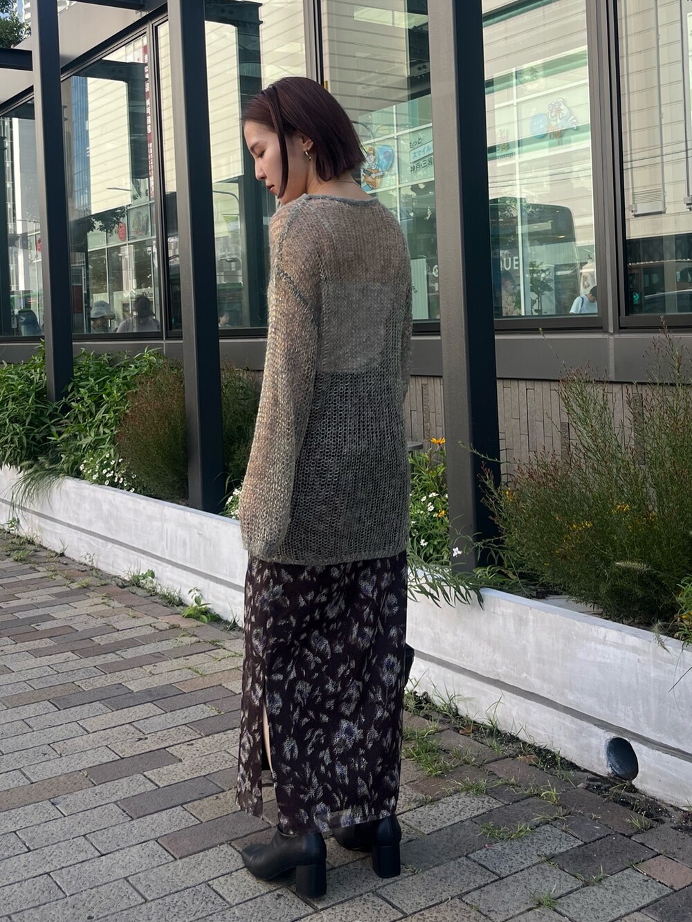 ブラック系のショルダーバッグ、グレー系のニット/セーター、ブラウン系のスカートを着用したレディースの秋コーディネートの3枚目の写真