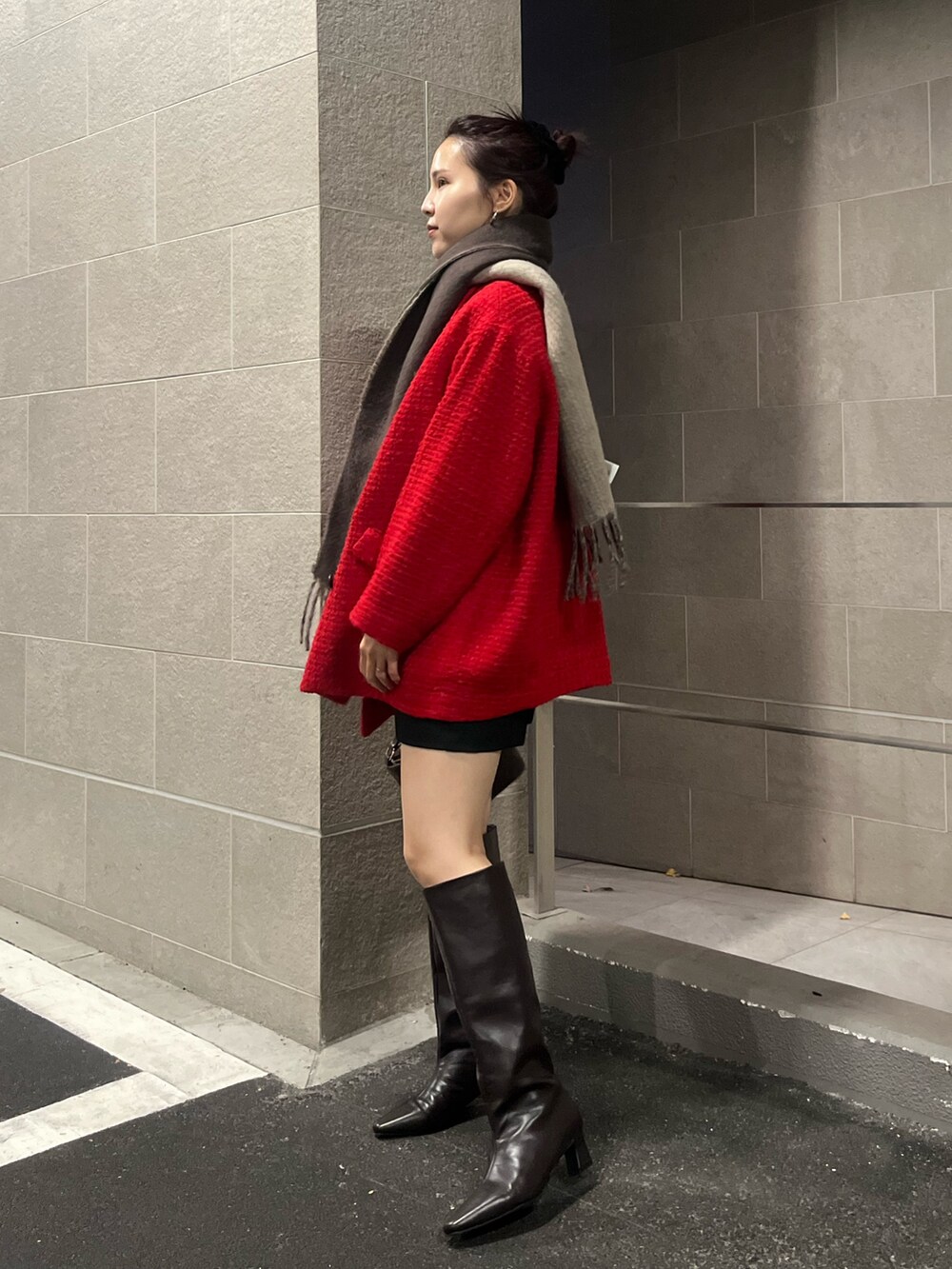ブラウン系のブーツ、ブラック系のその他パンツ、レッド系のその他アウターを着用したレディースの冬コーディネートの2枚目の写真