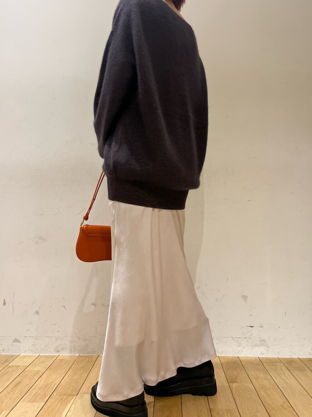 ホワイト系のスカート、オレンジ系のショルダーバッグ、ブラック系のブーツを着用したレディースの秋コーディネートの3枚目の写真