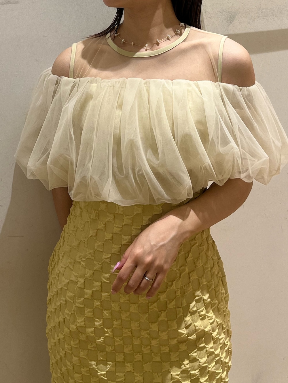 イエロー系のドレス、ブラック系のパンプスを着用したレディースの春コーディネートの4枚目の写真