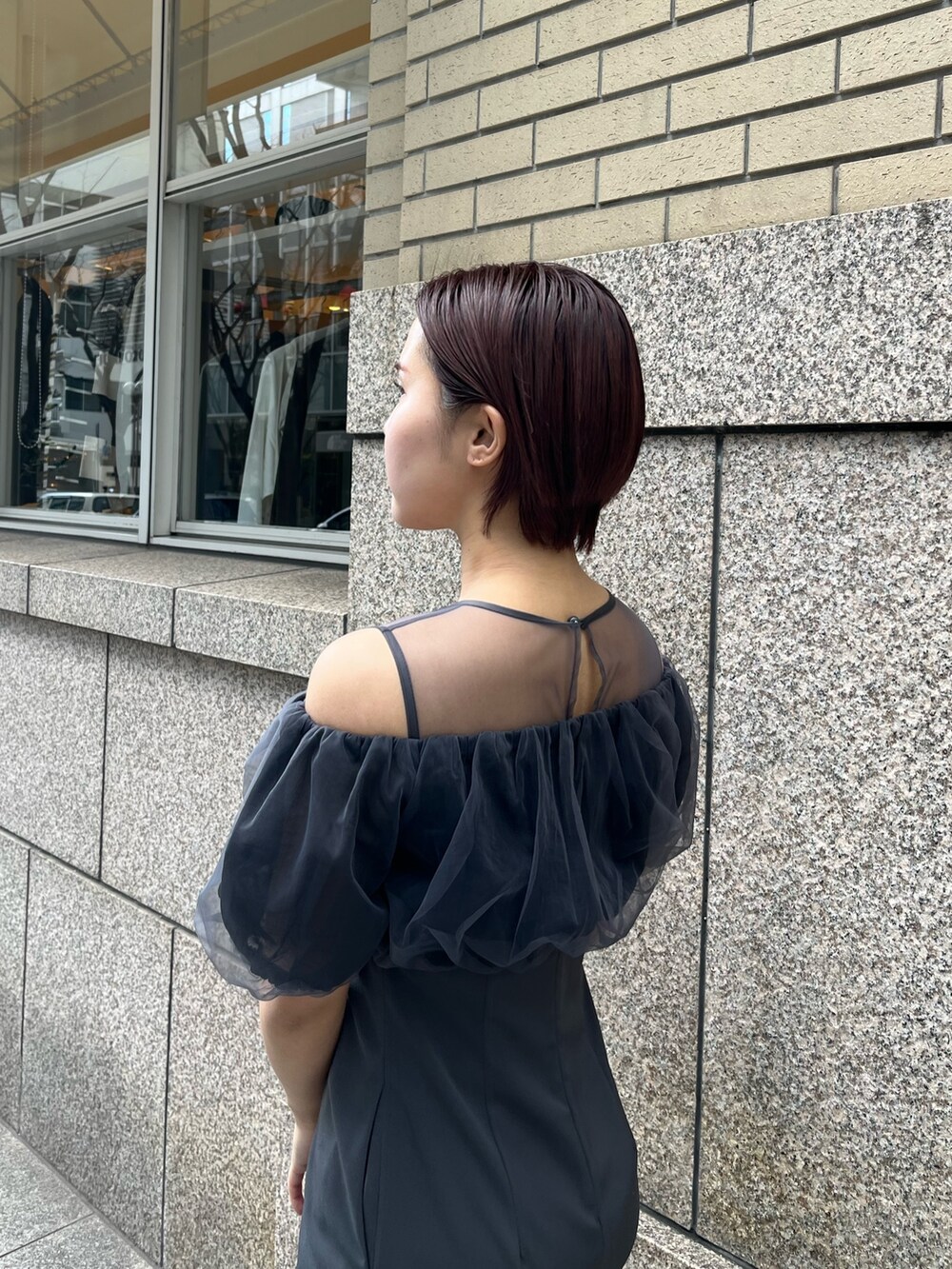 グレー系のドレス、シルバー系のパンプス、シルバー系のハンドバッグを着用したレディースの冬コーディネートの7枚目の写真