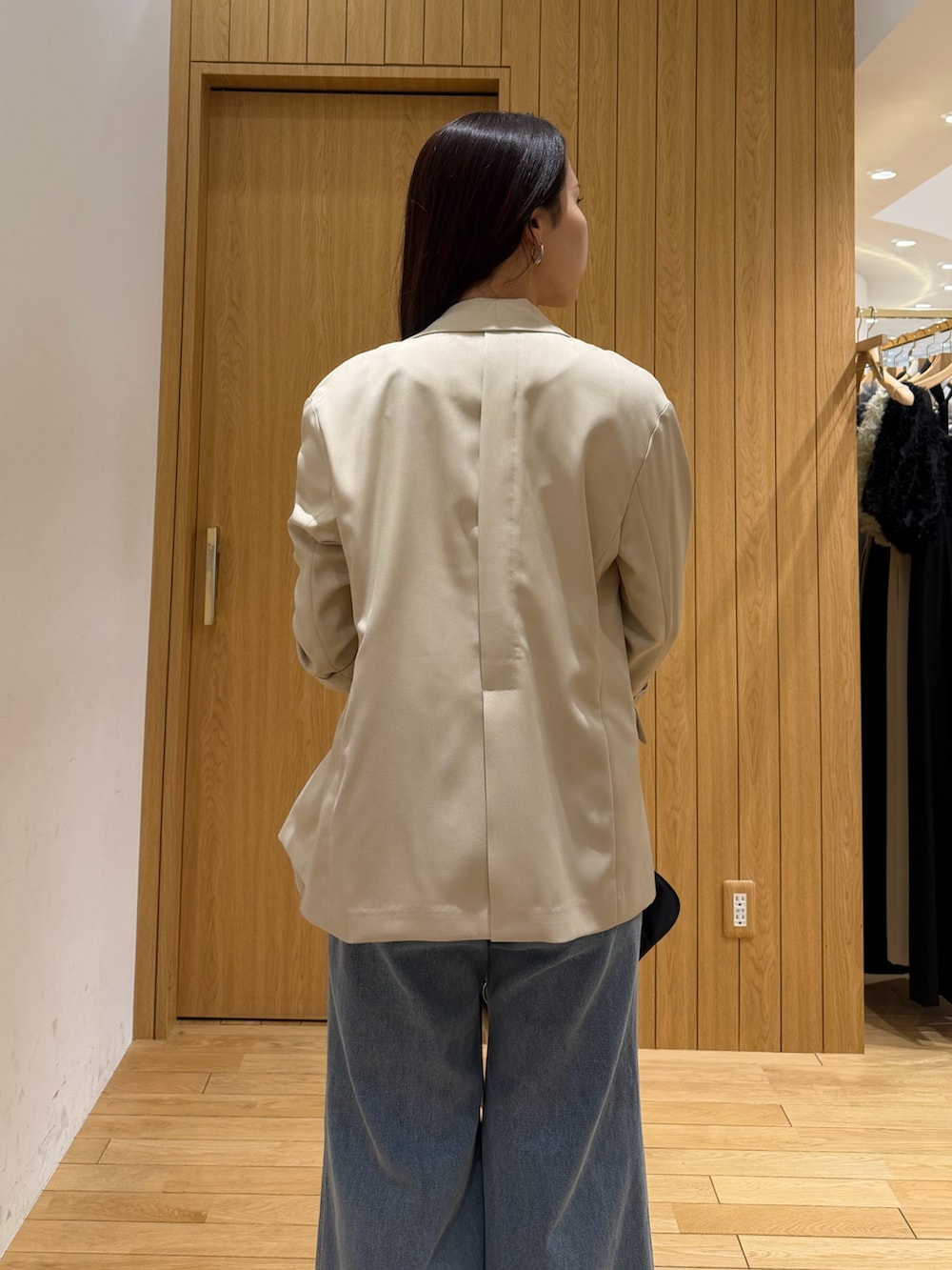 ブルー系のデニムパンツ、ホワイト系のタンクトップ、ベージュ系のテーラードジャケットを着用したレディースの春コーディネートの5枚目の写真