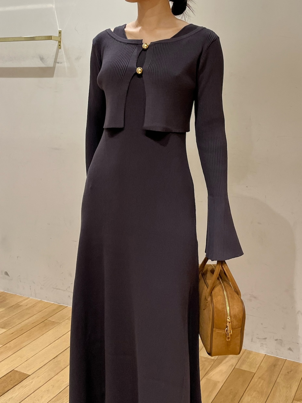 ブラック系のブーツ、グレー系のワンピース、ブラウン系のハンドバッグを着用したレディースの秋コーディネートの5枚目の写真