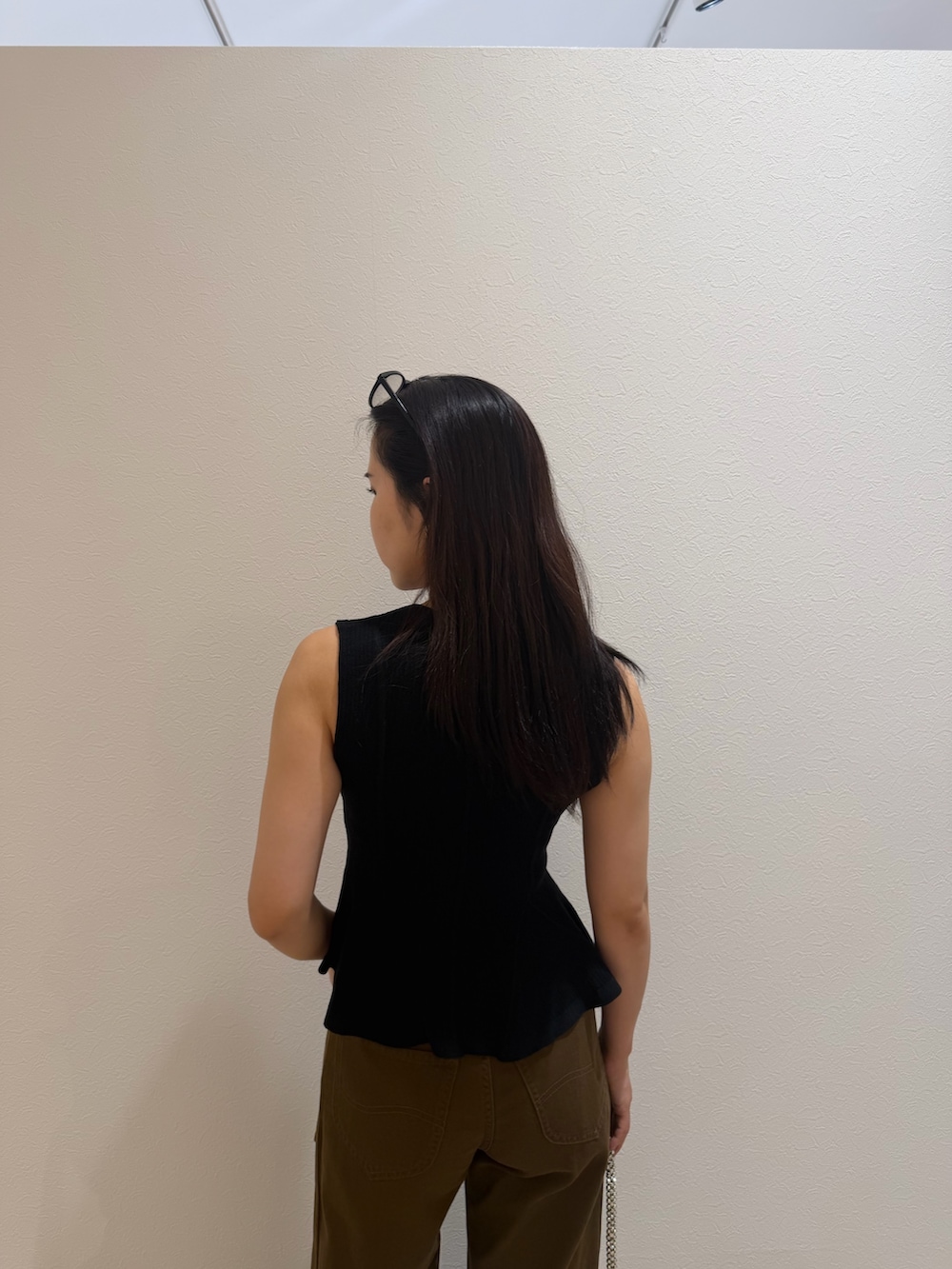 ブラック系のニット/セーター、ブラウン系のデニムパンツ、ブラウン系のサンダルを着用したレディースの夏コーディネートの5枚目の写真