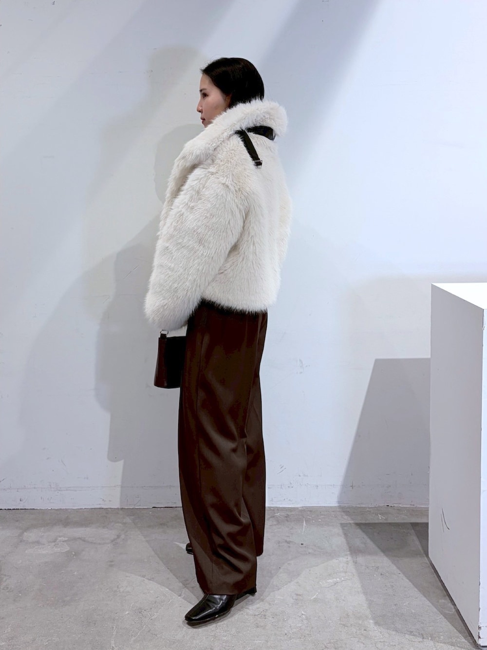 ブラウン系のその他パンツ、レッド系のニット/セーター、ホワイト系のその他アウターを着用したレディースの夏コーディネートの2枚目の写真