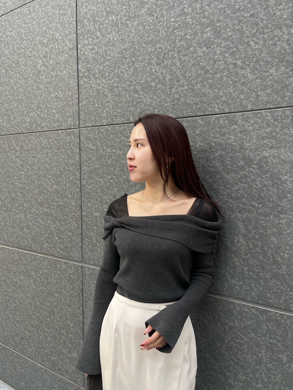 ホワイト系のスカート、ブラウン系のショルダーバッグ、ブラック系のニット/セーターを着用したレディースの冬コーディネートの5枚目の写真