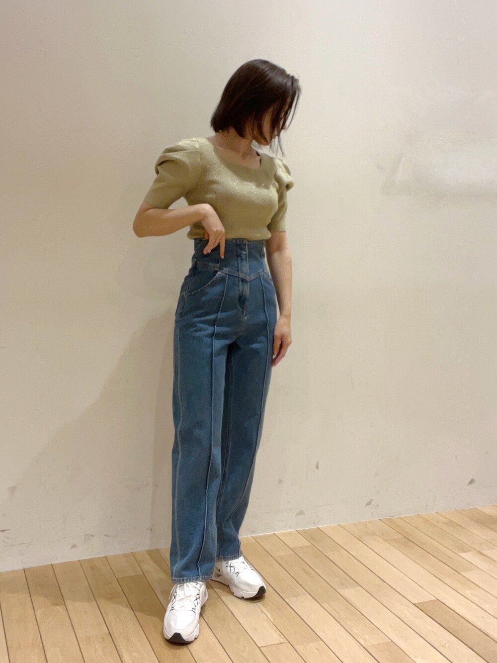 ベージュ系のニット/セーター、ブルー系のデニムパンツ、グリーン系のハンドバッグを着用したレディースの春コーディネートの5枚目の写真