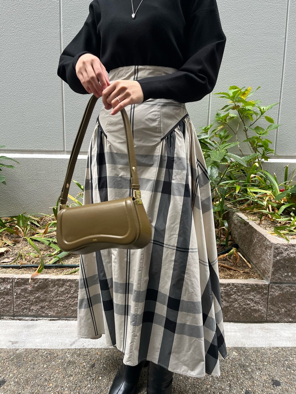 ホワイト系のワンピース、ブラック系のブーツ、ブラウン系のショルダーバッグを着用したレディースの冬コーディネートの6枚目の写真