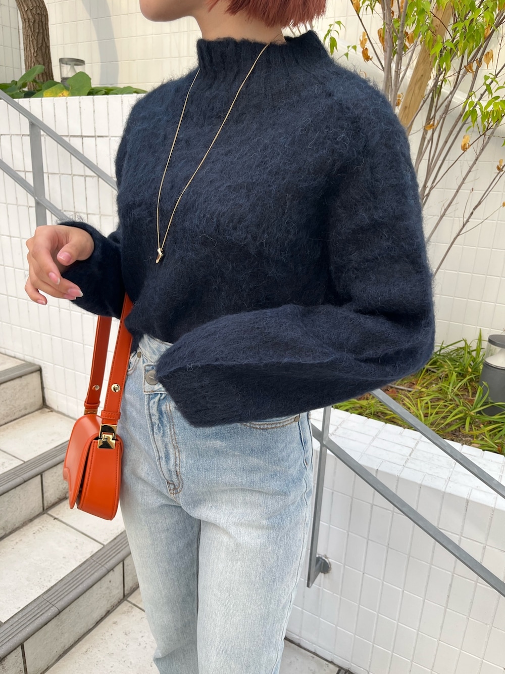 ブルー系のニット/セーター、ホワイト系のその他アウター、ブルー系のデニムパンツを着用したレディースの秋コーディネートの7枚目の写真