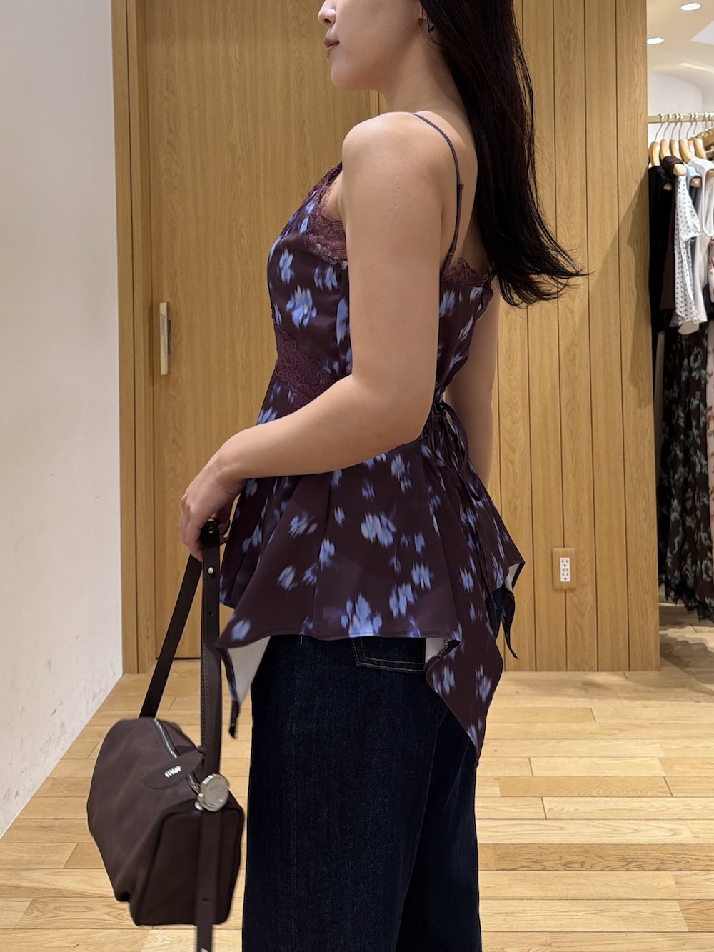 レッド系のキャミソール、ブルー系のデニムパンツ、レッド系のブーツを着用したレディースの秋コーディネートの5枚目の写真
