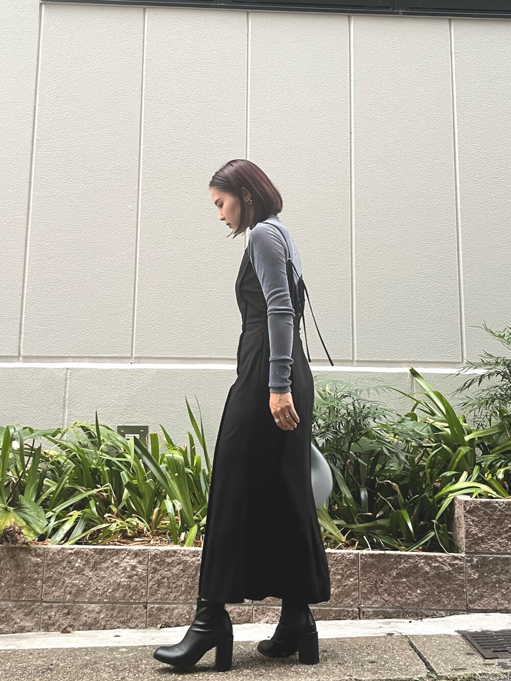 ブルー系のハンドバッグ、ブラック系のワンピース、ブルー系のTシャツ/カットソーを着用したレディースの秋コーディネートの2枚目の写真