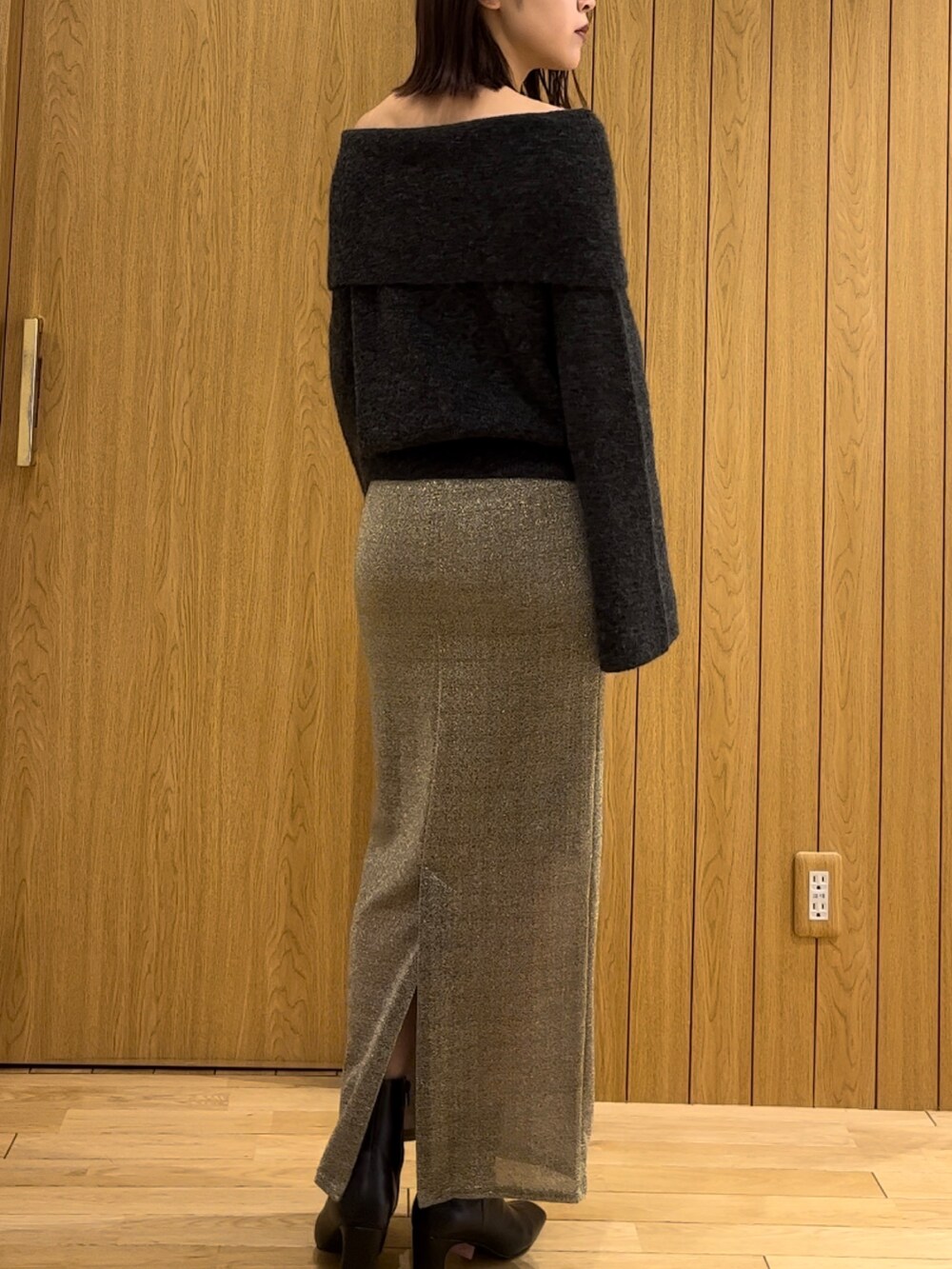 ゴールド系のスカート、ブラック系のブーツ、グレー系のニット/セーターを着用したレディースの冬コーディネートの3枚目の写真