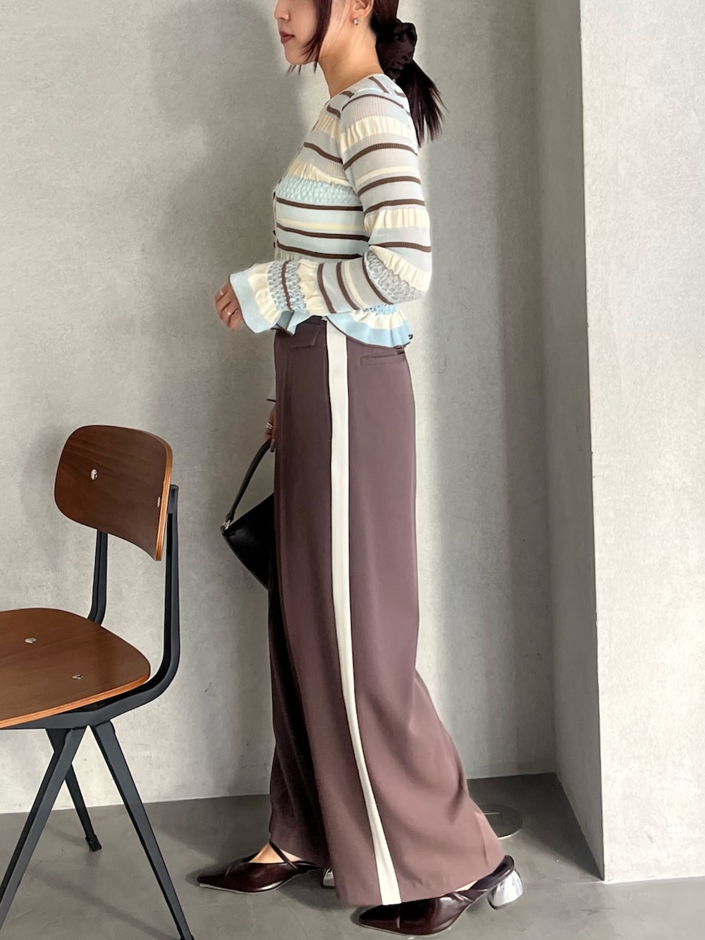 ブラウン系のハンドバッグ、ブラウン系のパンプス、ブラウン系のその他パンツを着用したレディースの冬コーディネートの2枚目の写真