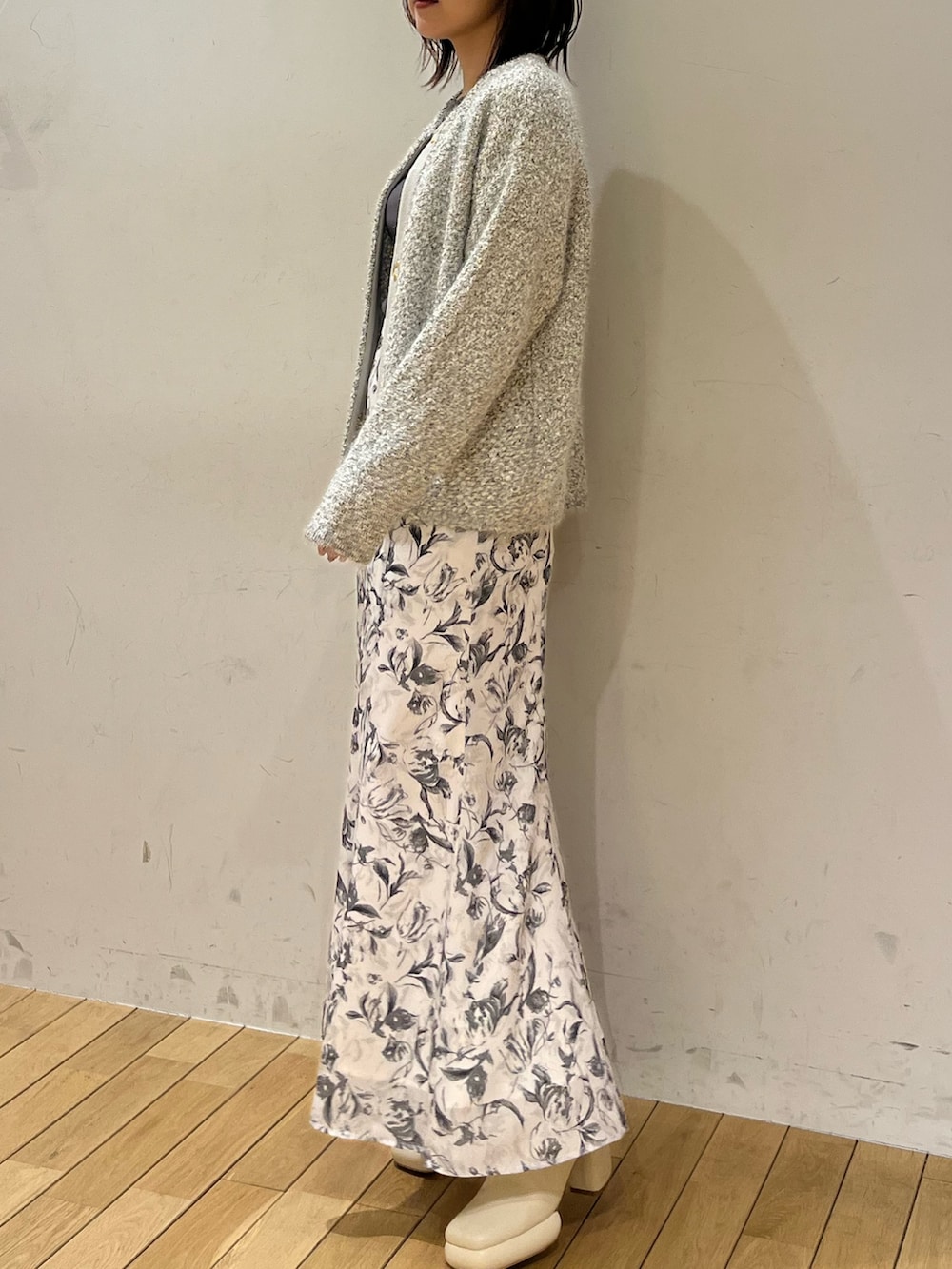 グレー系のスカート、グレー系のニット/セーター、グレー系のカーディガン/ボレロを着用したレディースの冬コーディネートの2枚目の写真