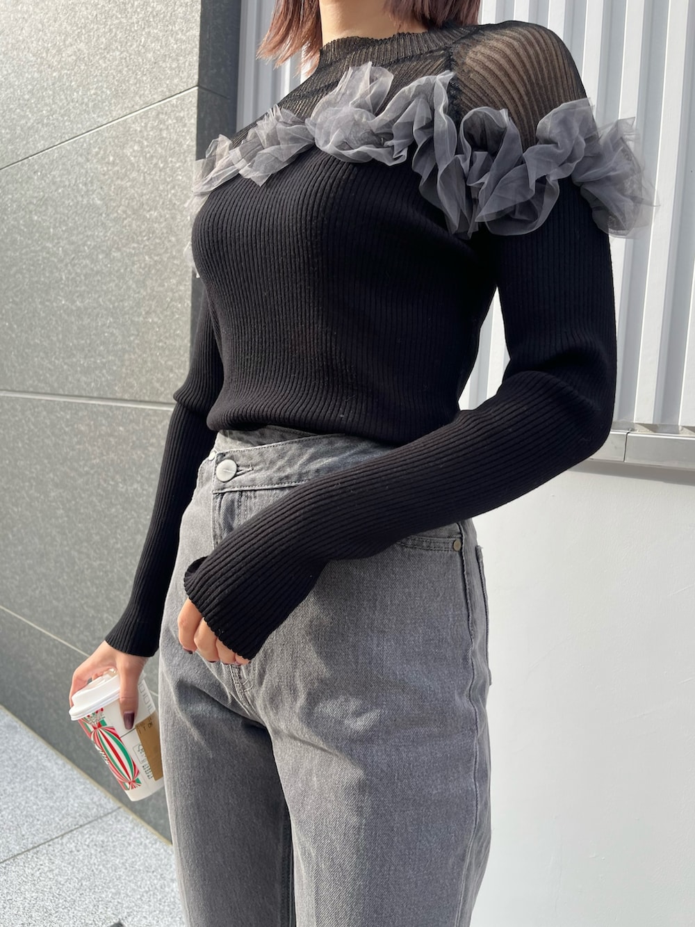 ブラック系のデニムパンツ、ブラック系のニット/セーターを着用したレディースの秋コーディネートの5枚目の写真