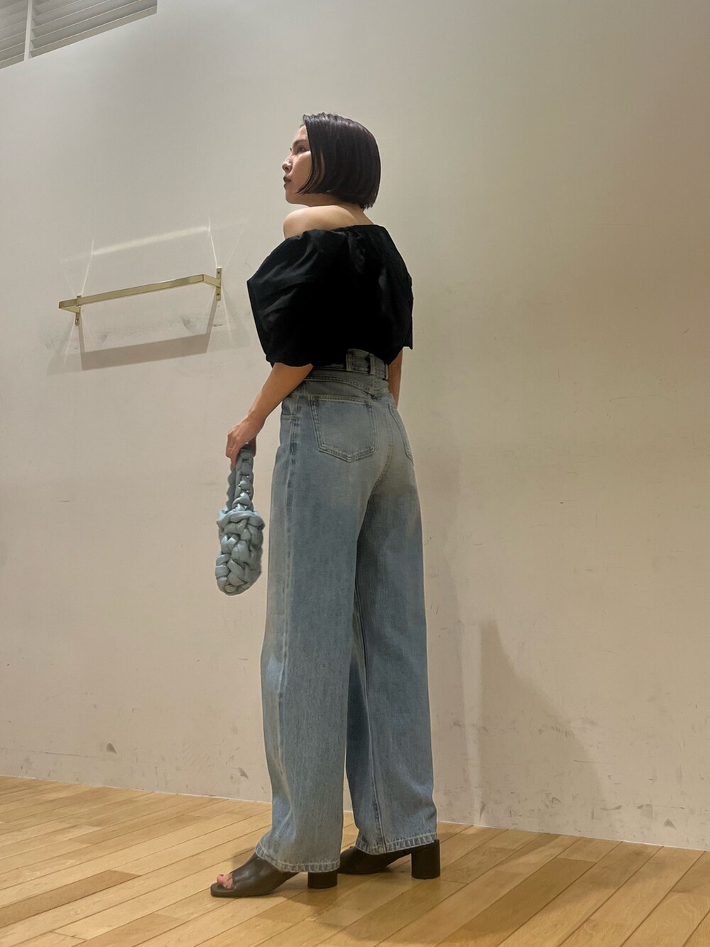 ブルー系のデニムパンツ、ブラック系のシャツ/ブラウス、ブラック系のサンダルを着用したレディースの夏コーディネートの3枚目の写真