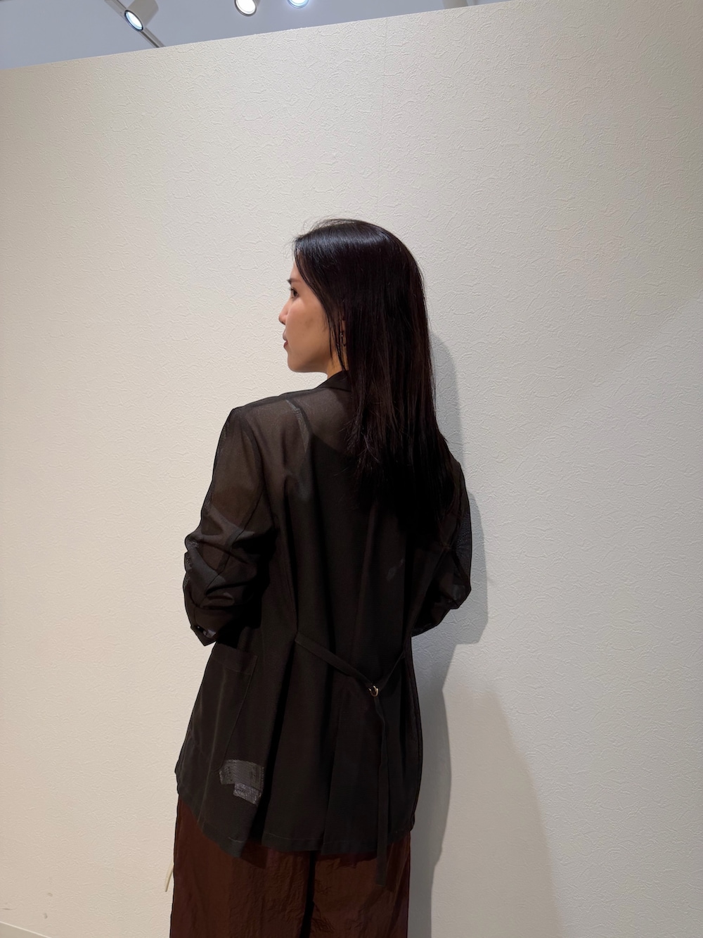 ブラック系のパンプス、ホワイト系のハンドバッグ、ブラウン系のその他パンツを着用したレディースの夏コーディネートの6枚目の写真