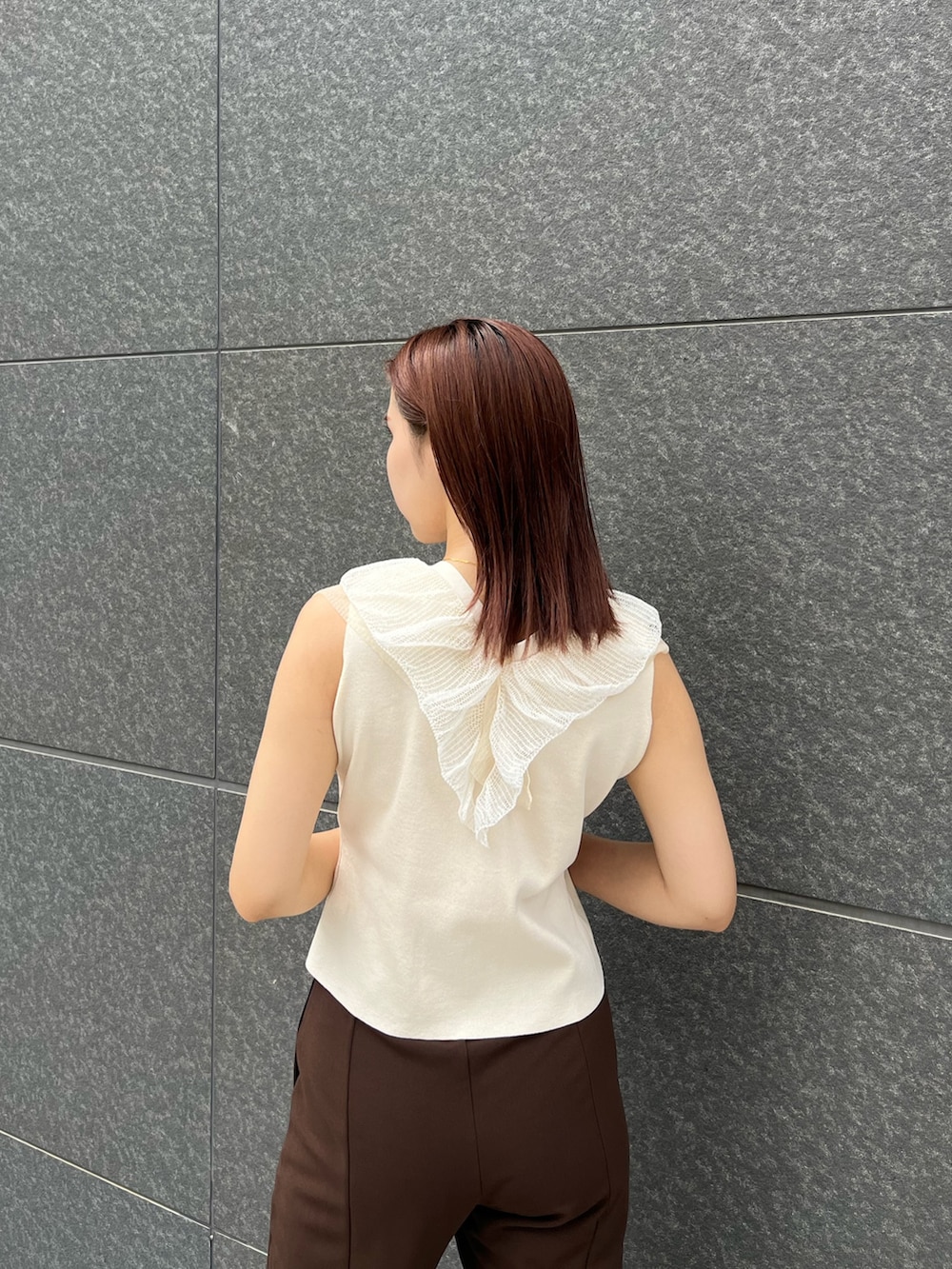 ホワイト系のニット/セーター、ブラウン系のその他パンツ、ブラウン系のボストンバッグを着用したレディースの夏コーディネートの7枚目の写真