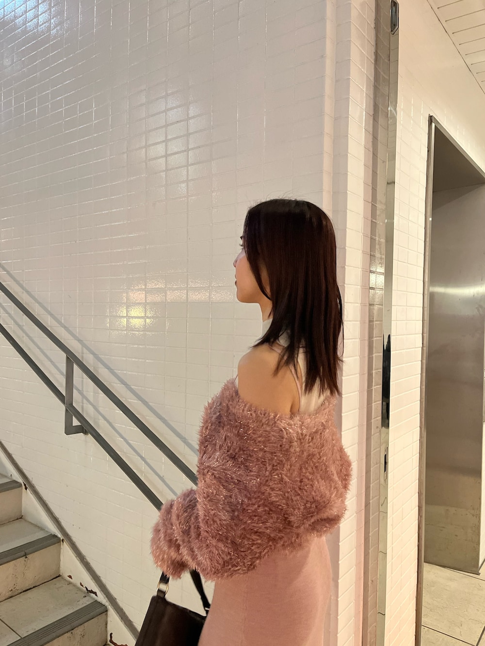 ピンク系のワンピース、ブラウン系のハンドバッグを着用したレディースの冬コーディネートの5枚目の写真