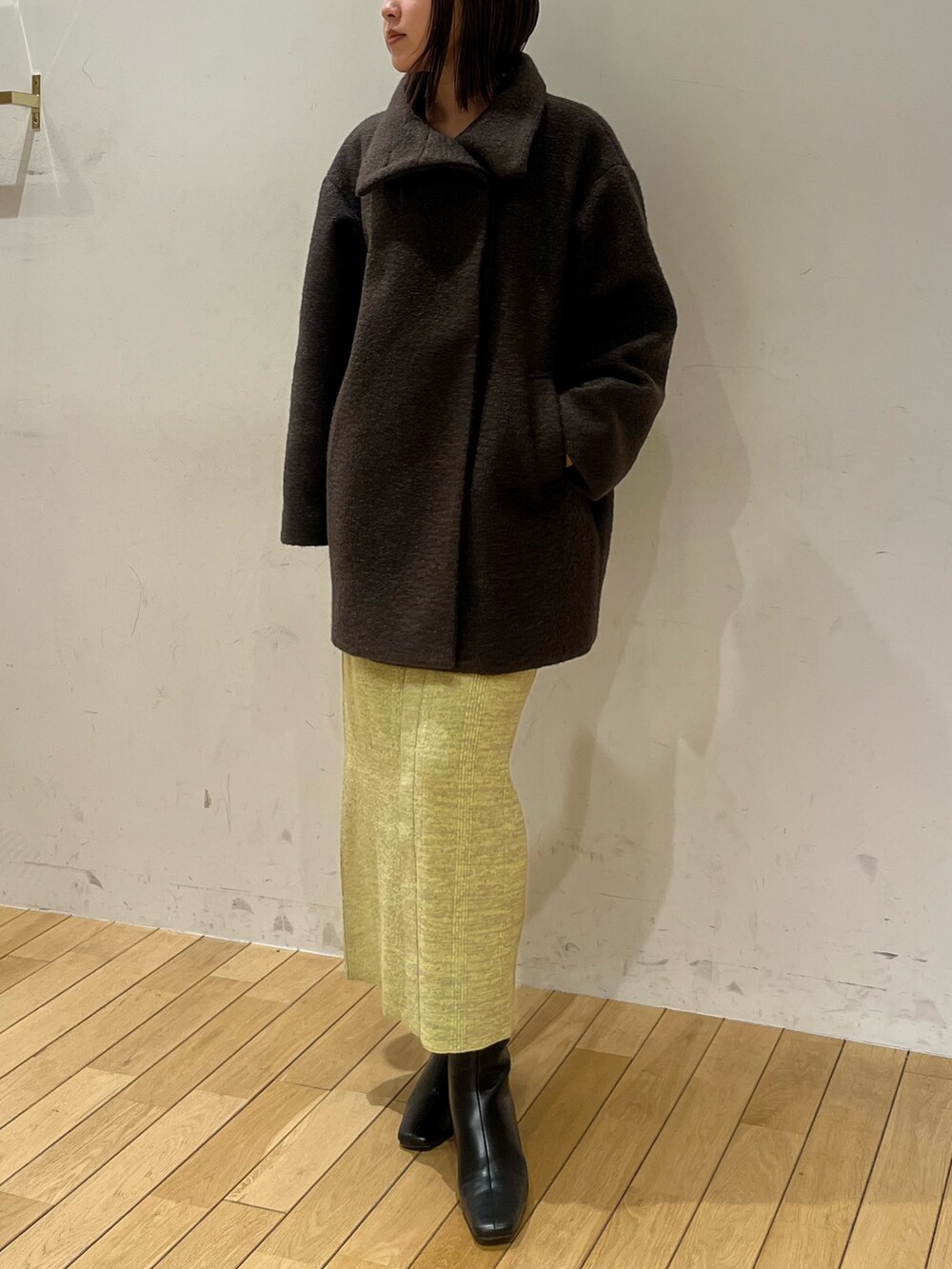 ブラウン系のその他アウター、グリーン系のワンピース、ブラック系のブーツを着用したレディースの冬コーディネートの4枚目の写真