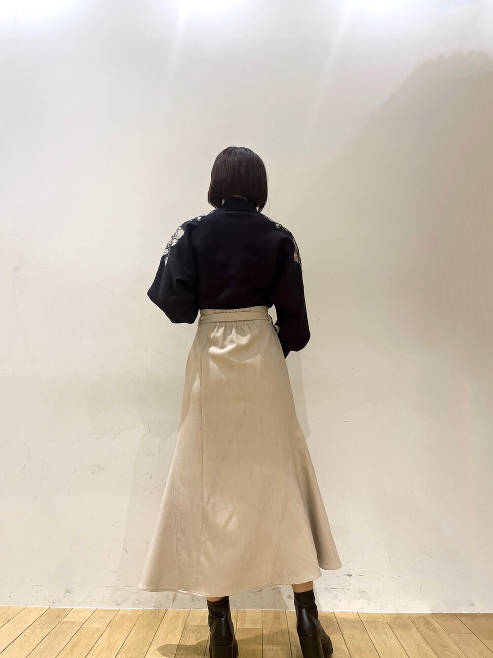 グレー系のニット/セーター、ベージュ系のスカートを着用したレディースの夏コーディネートの3枚目の写真