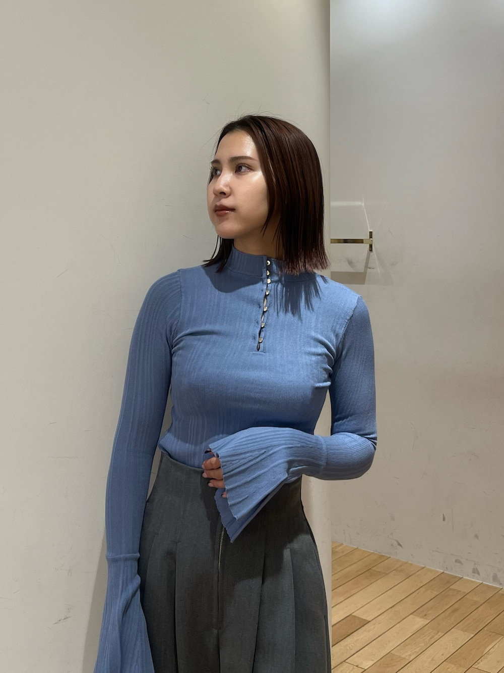 ブルー系のニット/セーター、グレー系のその他パンツ、ホワイト系のダウンジャケット/コートを着用したレディースの冬コーディネートの6枚目の写真