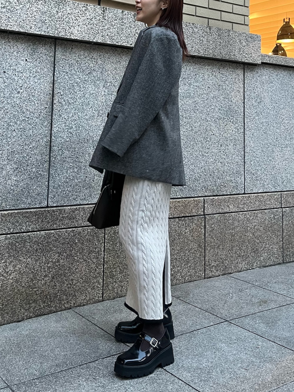 ブラウン系のボストンバッグ、ブラック系のローファー、ベージュ系のワンピースを着用したレディースの秋コーディネートの2枚目の写真